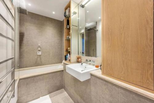 uma casa de banho com um lavatório branco e um chuveiro em Stunning Mayfair 3 bed flat with terrace and fireplace em Londres