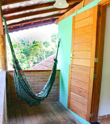 a hammock in a room with a window at Hotel da Inês in Visconde De Maua