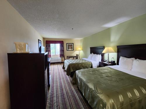 a hotel room with two beds and a window at Quality Inn in Wheelersburg