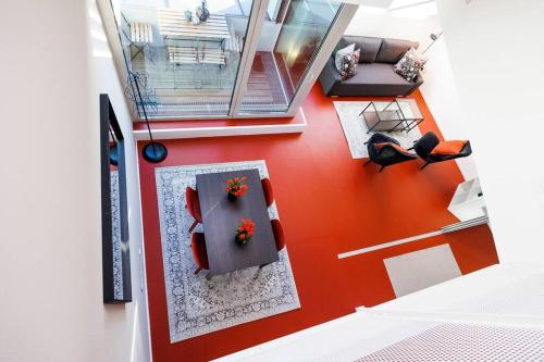 einen Blick über ein Wohnzimmer mit einer roten Wand in der Unterkunft Julius 25 Modern Comfort - 5 Mins to Vienna's City Center in Wien
