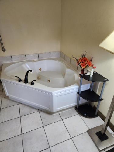 eine große weiße Badewanne in einem Zimmer mit einem Tisch in der Unterkunft Quality Inn in Wheelersburg