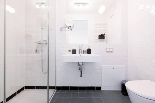 uma casa de banho branca com um lavatório e um chuveiro em Julius 25 Modern Comfort - 5 Mins to Vienna's City Center em Viena