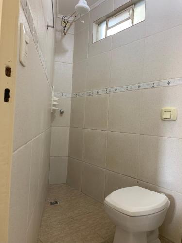a bathroom with a white toilet and a window at Pissin Plaza Hotel in Goiânia