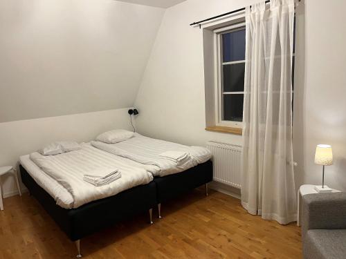 ein kleines Schlafzimmer mit einem Bett und einem Fenster in der Unterkunft Österport - Visby Lägenhetshotell in Visby