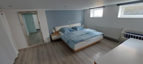 a bedroom with a bed and a large mirror at Traumblick Südpfalz in Burrweiler