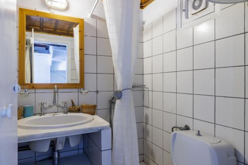 a bathroom with a sink and a mirror and a toilet at The Lemon Tree House in Skopelos Town