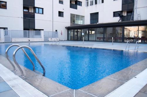 a large swimming pool in front of a building at Apartamento Vips Suites in Murcia