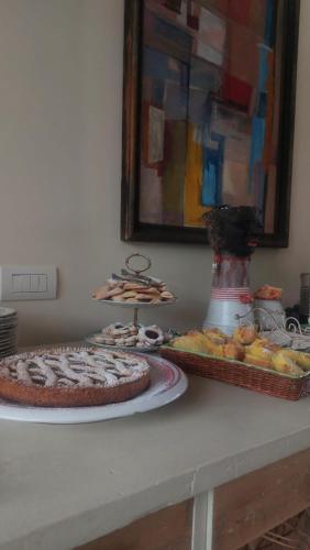 a table with a pie and a tray of pastries at Pioppi Neri R&B in Felino