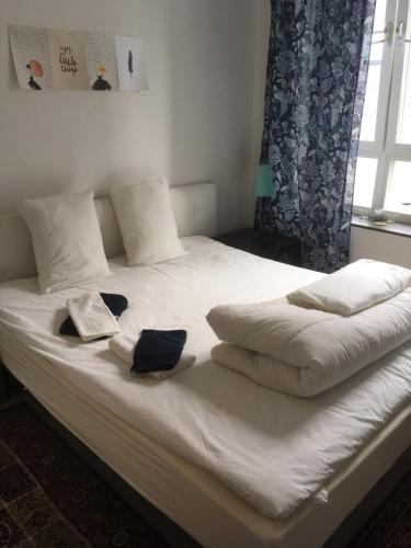 a bed with white sheets and pillows and a window at Beautiful 1- Bed Studio in Sollentuna in Sollentuna