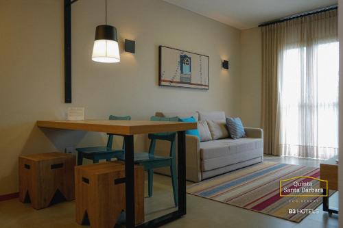 uma sala de estar com uma mesa e um sofá em Resort Quinta Santa Bárbara OFICIAL em Pirenópolis