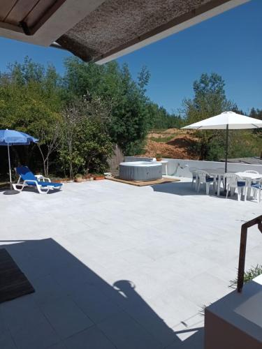 a large patio with chairs and umbrellas on it at vivenda do Sobreiro AL in Serpins