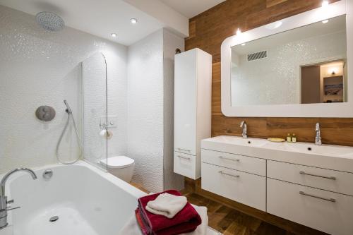 une salle de bain avec une baignoire blanche et un lavabo dans l'établissement Chauvain Résidence, à Nice