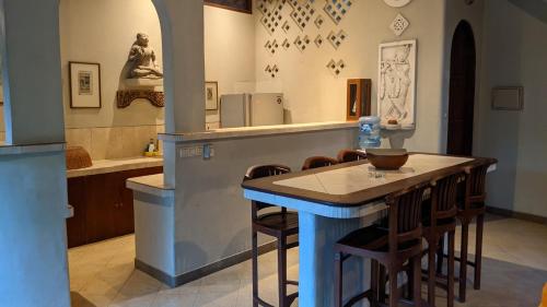 a kitchen with a bar with stools in a room at Ben Bali Villa in Seminyak