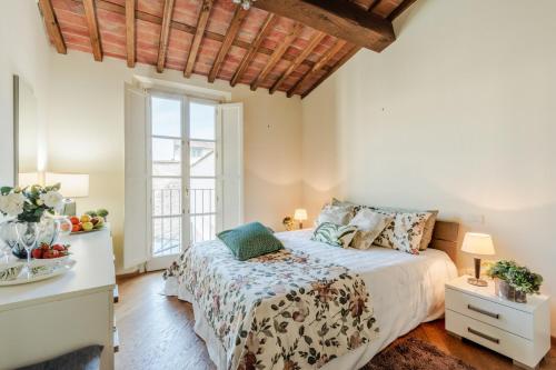 a bedroom with a bed and a window at Helene Smart Flat with Elevator inside Lucca in Lucca