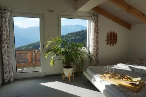 a bedroom with a bed and a large window at HERZLI-CHALET über dem Rheintal mit Schlossblick in Werdenberg