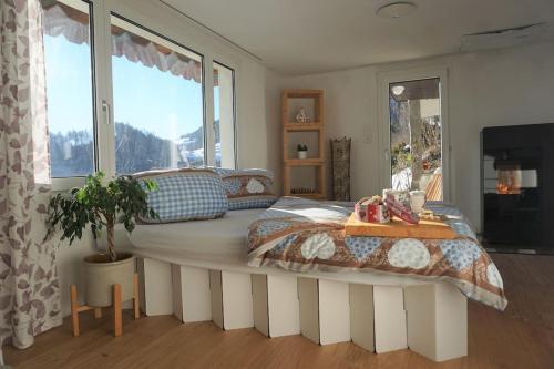 a bedroom with a large bed with a large window at HERZLI-CHALET über dem Rheintal mit Schlossblick in Werdenberg