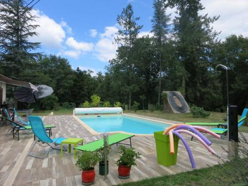 - une piscine avec des chaises, des tables et un parasol dans l'établissement Gîte O 3 Cèdres, à Magescq