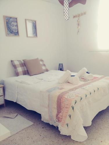 um quarto com 2 camas e lençóis brancos em casa roja marbella em Marbella