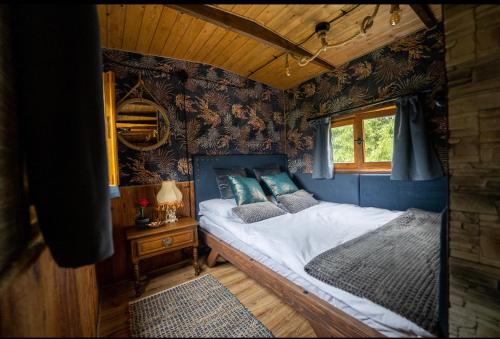 a bedroom with a bed in a room with wallpaper at Gypsy Hill in Międzylesie