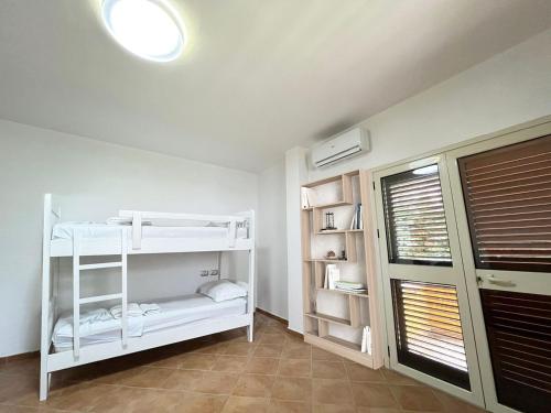 a room with a white bunk bed and a window at Belix Hotel Apartments, Near the Beach in Durrës