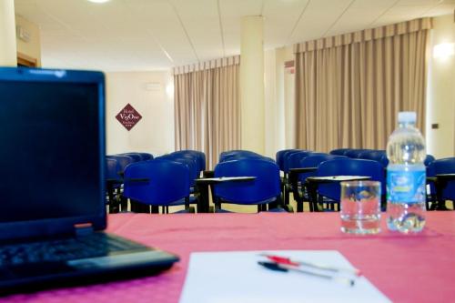 un ordenador portátil sentado en una mesa con una botella de agua en Hotel Residence Vigone, en Vigone