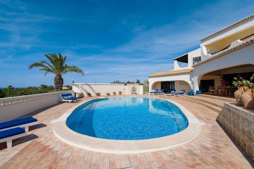 a villa with a swimming pool and a house at Villa Canto dos Buzios in Carvoeiro