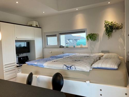 - une chambre avec un grand lit et une télévision dans l'établissement Ausguck, à Wangerooge