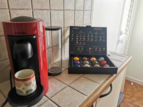 a box of balls on a counter next to a coffee maker at Le Théâtre du Vieux Foyal - Appartement 4 personnes à Fort-De- France in Fort-de-France