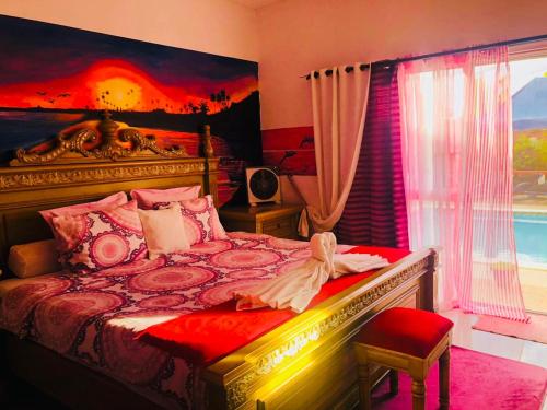 a bedroom with a large bed and a window at Petite Flower Guest House in Talata-maty