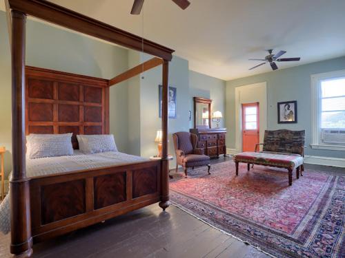 a bedroom with a large canopy bed and a living room at Shamokin Bed and Breakfast in Shamokin