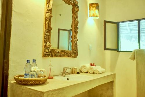 a bathroom with a sink and a mirror at Mvuvi Lodge in Watamu