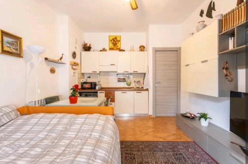 a small bedroom with a bed and a kitchen at Camera privata nell'appartamento in zona residenziale con 2 piscine in Rapallo