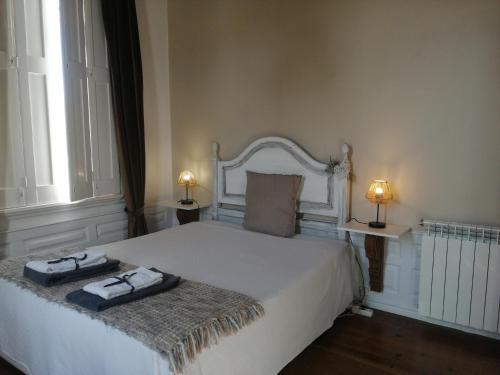 um quarto com uma cama branca com duas toalhas em Vila Delfina em Lousã