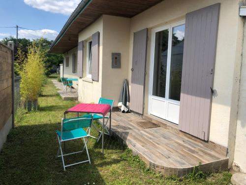 una terraza con mesa y sillas en una casa en Charmant séjour à Andernos en Andernos-les-Bains