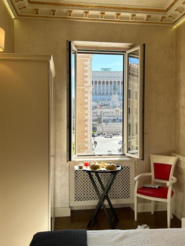 una camera con finestra, tavolo e sedia di Piazza Venezia Luxury Suite a Roma