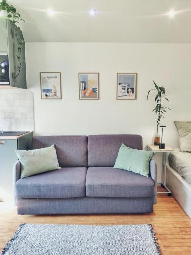 - un salon avec un canapé bleu et un lit dans l'établissement Studio à La Grande Plage de Biarritz, à Biarritz