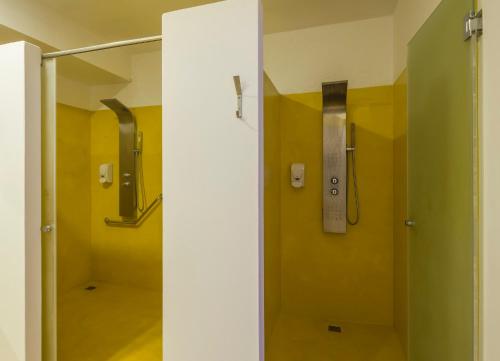 a bathroom with a shower with yellow walls at ILUNION Costa Sal Lanzarote in Puerto del Carmen