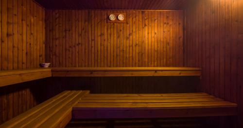 a sauna with a bench and a clock on the wall at ILUNION Costa Sal Lanzarote in Puerto del Carmen