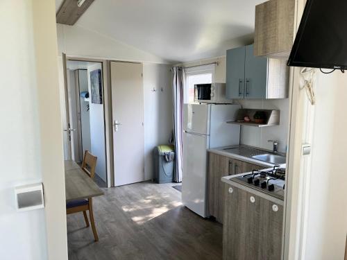 a small kitchen with a sink and a refrigerator at Camping De Collignon in Cherbourg en Cotentin