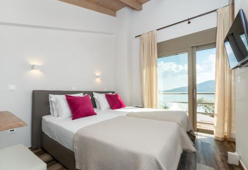 deux lits dans une chambre avec une grande fenêtre dans l'établissement Acqua Di Mare - Villa Bella, à Nydri