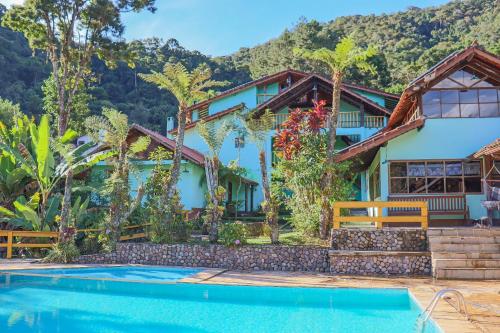 una casa con una piscina di fronte di Hotel da Inês a Visconde De Maua
