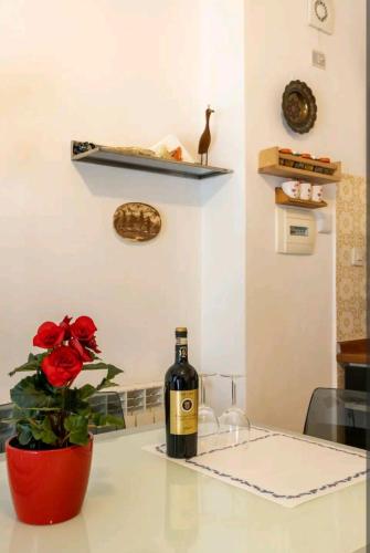 a bottle of wine sitting on a counter with a flower at Camera privata nell'appartamento in zona residenziale con 2 piscine in Rapallo