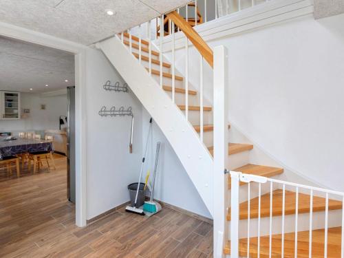 Una escalera blanca en una casa con comedor en Two-Bedroom Holiday home in Løkken 6, en Løkken