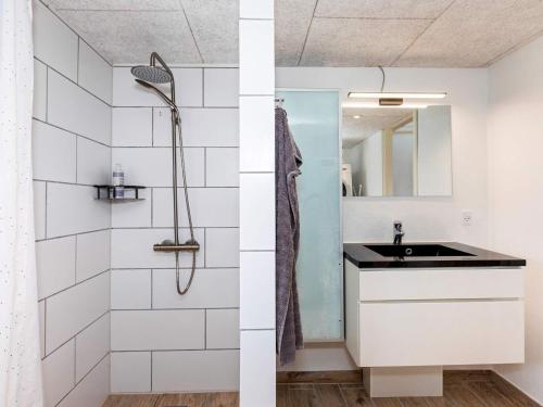 y baño con lavabo y ducha. en Two-Bedroom Holiday home in Løkken 6, en Løkken