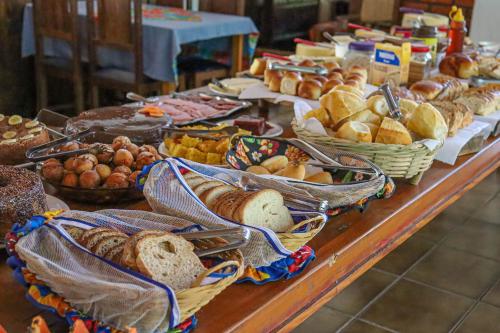 una tavola piena di diversi tipi di pane di Hotel da Inês a Visconde De Maua