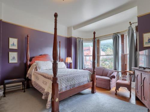a bedroom with a bed and a chair and a window at Shamokin Bed and Breakfast in Shamokin