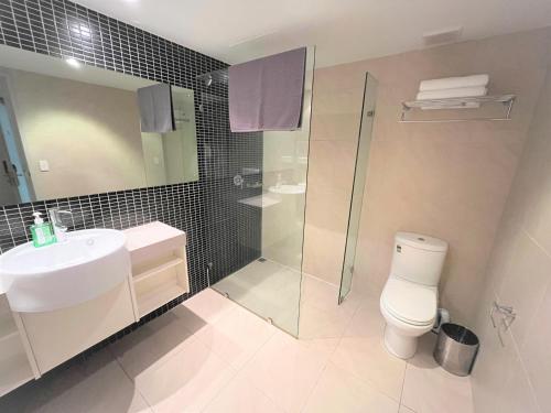 y baño con aseo, lavabo y ducha. en Darwin City Suites with Harbour View, en Darwin