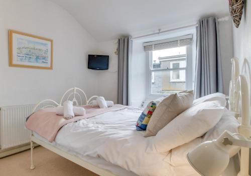 un letto bianco in una stanza con finestra di 9 Teetotal Street a St Ives