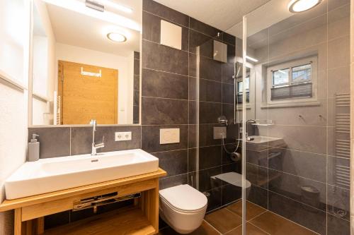 a bathroom with a sink and a toilet and a shower at Tauernlodges Uttendorf by ALPS RESORTS in Uttendorf