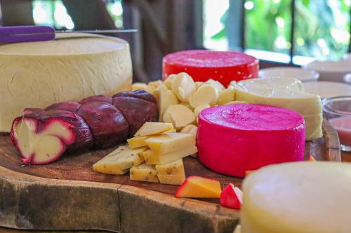a cutting board with cheese and meats and candles at Hotel da Inês in Visconde De Maua